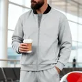 Detalle de chaqueta gris para hombre con cremallera, cuello levantado y puños elásticos. - Gris claro