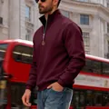 Close-up of men's wine red quarter-zip sweatshirt with stand collar in street scene - S / Burgundy