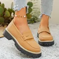 Detailopname van beige matte loafers met dikke plateauzolen en mocassinstiksels - Bruin