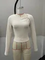 Close-up of cream ribbed knit top with unique asymmetrical neckline and knot detail - S / Tops / Apricot
