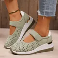Detail shot of green hollowed-out wedge sneakers with velcro strap and gold heel accents. - 37 / Green