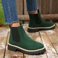 Detail shot of women's dark green suede platform Chelsea boots on a rustic wood floor. - 36 / Dark Green