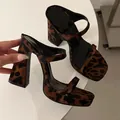 Close-up detail of leopard print platform sandals with thick heels and ankle straps. - 35 / Leopard Print