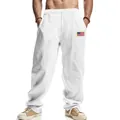 Detail view of men's white linen pants featuring an American flag patch and drawstring. - White
