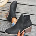 Close-up of black matte ankle boots with decorative hollow-out floral patterns - 36 / Black