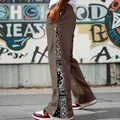 Detail view of men's brown straight hip-hop pants with paisley side snap buttons - S / Bottoms / Brown