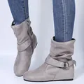 Detail shot of vintage grey suede slouchy ankle boots featuring decorative buckle strap - Gray