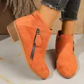 Close-up of orange suede ankle boots featuring a stylish side zipper and block heel - 36 / Orange