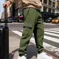 Dettaglio dei pantaloni cargo jacquard verde oliva da uomo in un ambiente urbano - Verde militare