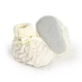 Macro view of cream fuzzy baby winter booties featuring a non-slip sole and knitted cuff. - 11cm / White