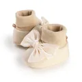 Close-up detail of cream baby booties featuring a large elegant satin bow for infants - 11cm / Beige