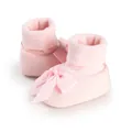 Close-up of pink baby shoe socks with elegant ribbon bow and ribbed cuffs - 11cm / Pink