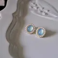 Nahaufnahme von Vintage-Ohrsteckern mit blauem Katzenaugenstein und kleinen Perlen. - 925 Silber Nadel Paar / Azurblaues Meer