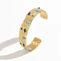 Close-up detail of a textured gold stainless steel C-shaped cuff with turquoise stones - Blue Turquoise Eye Hammered Style (S3218D)
