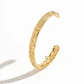 Macro view of gold stainless steel cuff bracelet with sun, moon, and star patterns - Star Moon Sun Relief Style (S3218J)