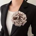 Elegant champagne polka dot peony fabric flower brooch pinned to a black blazer lapel - Khaki