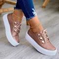 Close-up of rose gold platform sneakers with decorative gold buttons on a wooden floor. - 35 / Rose Gold