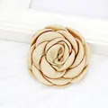 Macro detail of a 6cm handmade champagne gold satin camellia flower brooch accessory - Flat / Khaki