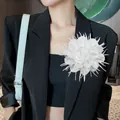 Detailopname van een 18 cm grote witte stoffen bloemspeld op een zwarte blazer - Wit