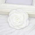 Close-up of a white handmade camellia fabric flower brooch and clothing accessory detail - Flat / White