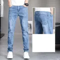 Men's light blue slim-fit stretch jeans with a back pocket detail view - 28 / Bottoms / Medium Blue