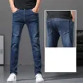Close-up shot of men's slim fit blue denim jeans showing front and back pocket detail - 28 / Bottoms / Dark Blue