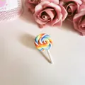 Close-up detail of a colorful polymer clay rainbow lollipop brooch accessory for bags - Thin Blue Red Yellow Lollipop Brooch