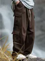 Detailed macro view of men's loose brown cargo pants styled in a misty outdoor setting - S / Coffee