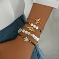 Elegante juego de 5 pulseras doradas apilables con perlas de imitación y colgante de corazón - Estilo de Cinco Piezas Clave de Sol (AB1201)