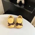 Close-up detail of yellow toddler German trainer shoes with decorative brown bows - 16 / Yellow
