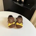 Close-up detail view of brown and yellow toddler walking shoes featuring Cinuorat logo branding. - 16 / Brown