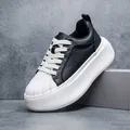 Side view of a premium black leather shell-toe sneaker with chunky white platform sole - 42 / Black
