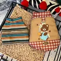 Close-up detail of dog winter harness vest with cute bear print and striped pet sweater - XS / Brown