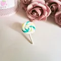 Close-up of a sweet polymer clay lollipop brooch with a teal and yellow spiral - Green Lollipop Brooch