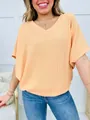 Close-up detail of a women's peach V-neck ribbed casual loose short sleeve T-shirt. - Earthy Yellow