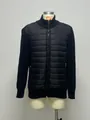 Dettaglio di una giacca ibrida trapuntata da uomo con maniche in maglia e collo alto - Taglia S / Top / Nero