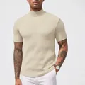 Nahaufnahme von beige Strickhemd mit Stehkragen, kurzem Arm und Rippenmuster-Textur - Milchweiß