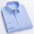 Chemise habillée à manches longues bleu clair pour hommes, pliée sur fond blanc. - 38 / Hauts / Bleu clair