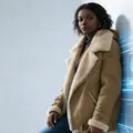 Detailed shot of a women's tan suede jacket with thick cream faux-fur lapels - S / Tops / Khaki