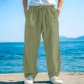 Detailed view of men's loose light green casual pants with drawstring waist at the beach - S / Bottoms / Light Green