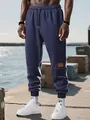 Vista detallada de pantalones jogger azul marino para hombre con forro polar en un modelo. - XS / Bottoms / Azul marino