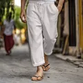 Detail of men's white cotton linen trousers with drawstring waist in a casual street setting - S / Bottoms / White