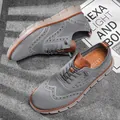 Detailed view of grey fly-knit casual shoes with brogue pattern and soft rubber sole. - 40 / Gray