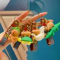 Detailopname van diverse capybara-sleutelhangers met schildpad, zwaan en krokodil - Mixed Stacked Styles