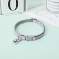 Detailed view of adjustable grey pet collar with pink paw prints and shiny silver bell - 1.0cm Width 19-32cm Adjustable / Silver