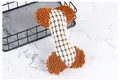 Durable bone-shaped squeaky plush dog toy with textured fabric for dental health. - White