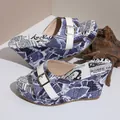 Detail view of vintage newspaper print wedge sandals with white belt buckle strap. - 36 / Light Blue