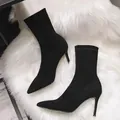 Detailansicht eleganter schwarzer Wildleder-Stiefeletten mit spitzer Kappe auf weißem Fell - 35 / Schwarz (Stiefeletten/7 cm Stiletto)