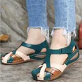 Detail view of retro wedge Roman sandals with teal, beige, and brown cross straps - 35 / Green