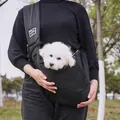 Close-up of a breathable black pet sling carrier being worn outdoors with a small white dog inside. - Mesh Pocket Style / 75*50cm / Black
